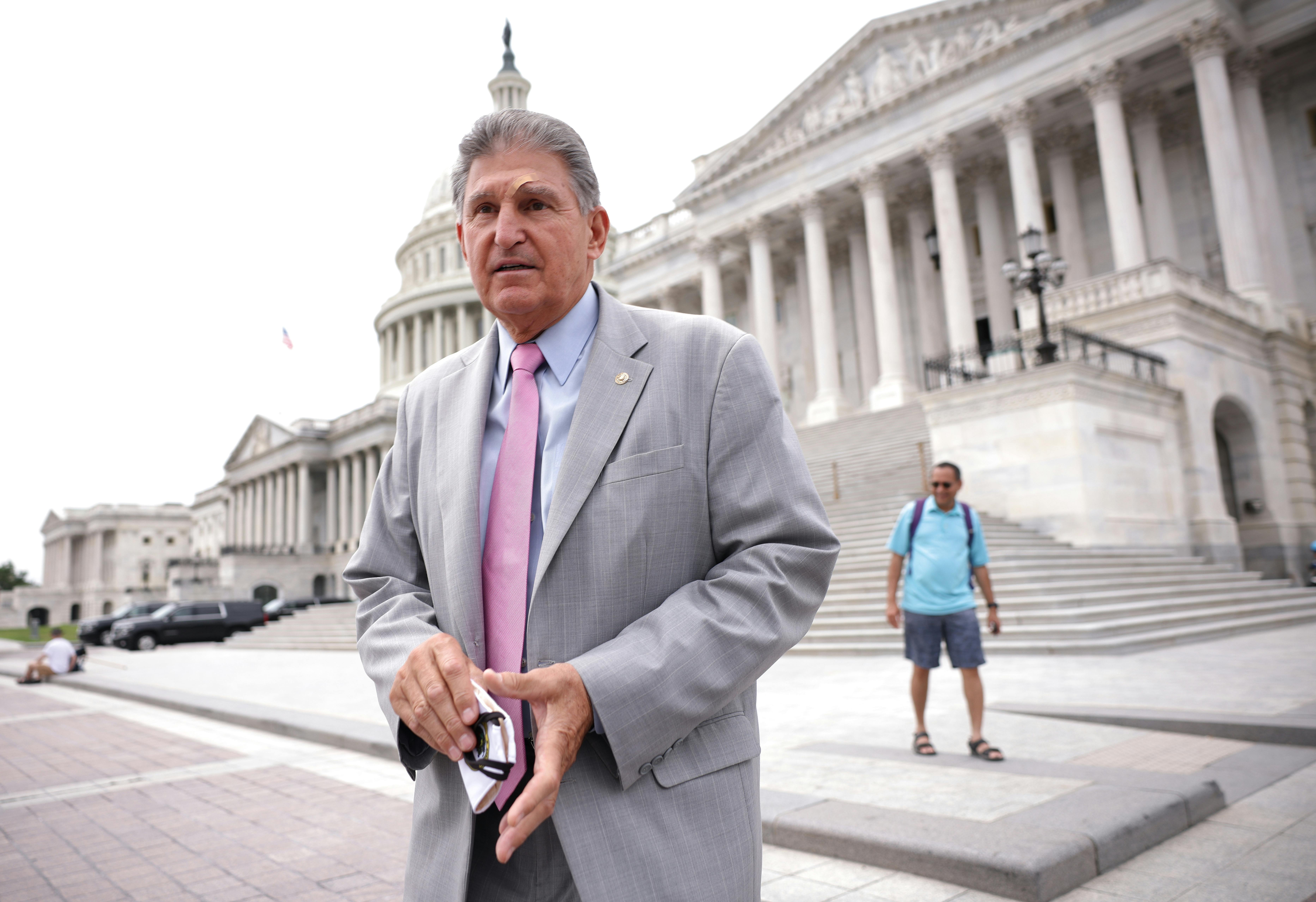 West Virginia Senator Joe Manchin stands on the steps of the U.S. Capitol.