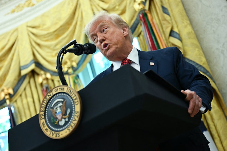Donald Trump speaks at a podium in the Oval Office