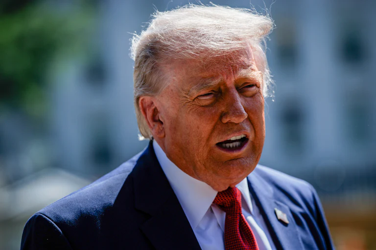 Donald Trump speaks while standing in front of the White House ballroom construction site