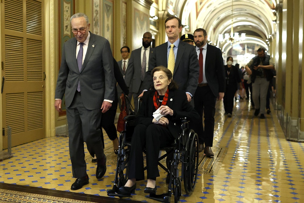Senate Majority Leader Charles Schumer escorts Senator Dianne Feinstein