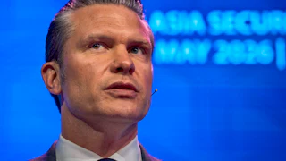 Secretary Pete Hegseth looks to the side