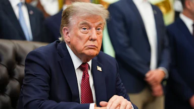 Donald Trump sits at his desk in the Oval Office.
