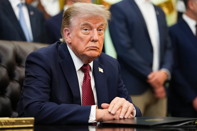 Donald Trump sits at his desk in the Oval Office.