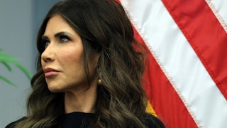 Homeland Security Secretary Kristi Noem turns her head to the side during a ceremony