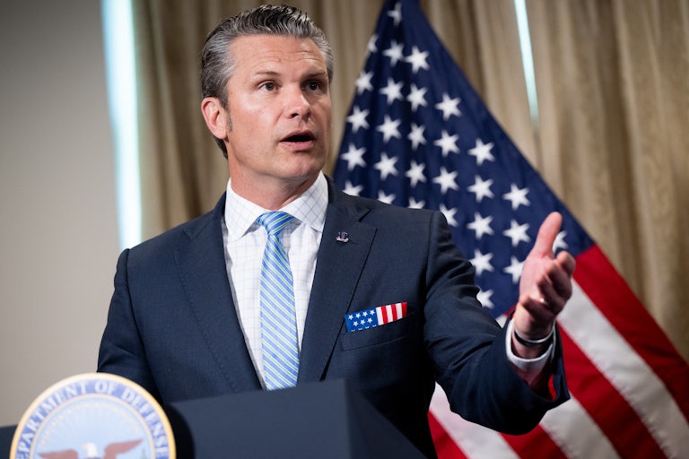 Secretary Pete Hegseth gestures while speaking at a podium