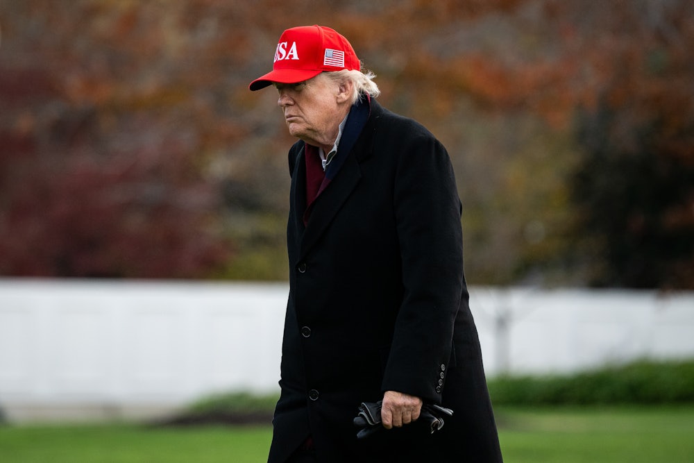 Donald Trump, wearing MAGA cap, walks with a stoop