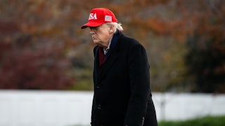 Donald Trump, wearing MAGA cap, walks with a stoop