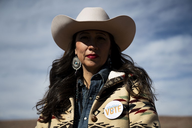 A Navajo woman wears a pin that says "Natives vote"