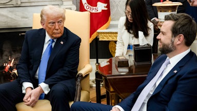 Donald Trump looks at JD Vance, who smiles back at him as they sit in the Oval Office