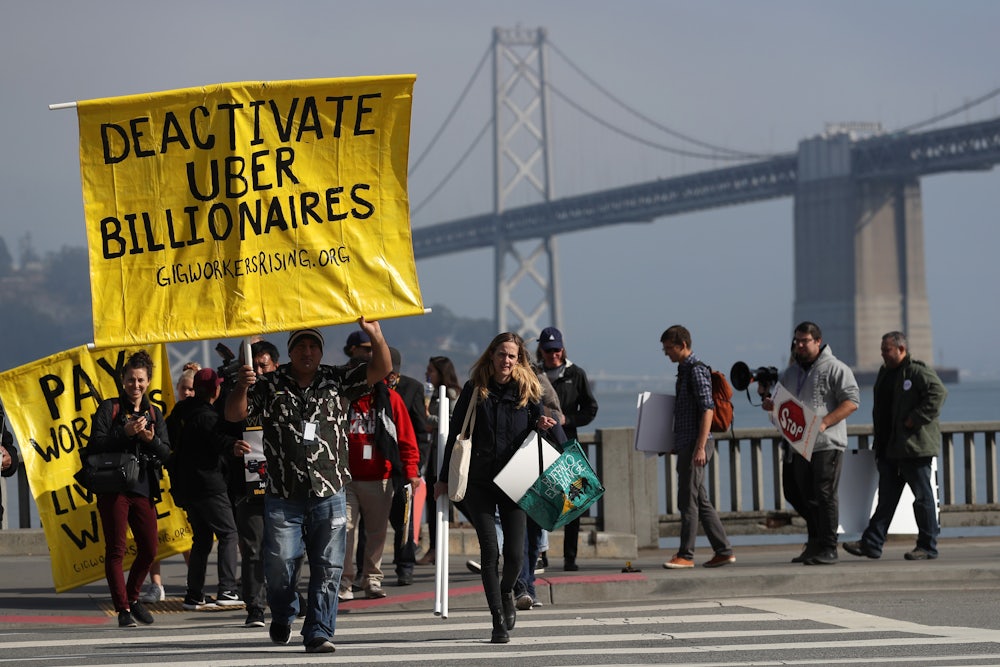 Uber and Lyft drivers hold a sign reading “Deactivate Uber Billionaires” during a protest in San Francisco.