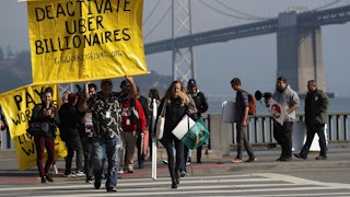 Uber and Lyft drivers hold a sign reading “Deactivate Uber Billionaires” during a protest in San Francisco.