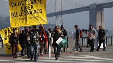 Uber and Lyft drivers hold a sign reading “Deactivate Uber Billionaires” during a protest in San Francisco.