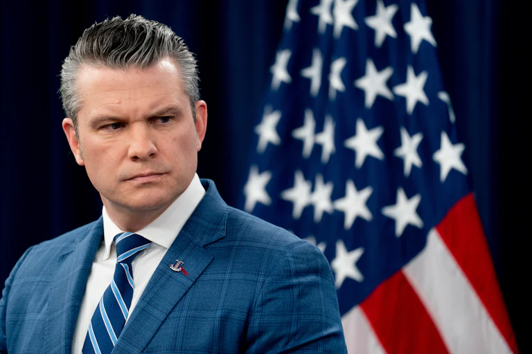 Defense Secretary Pete Hegseth frowns and looks to the side during a press conference