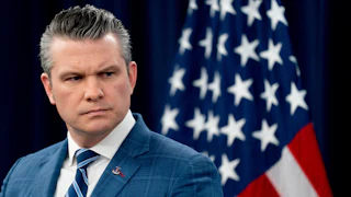 Defense Secretary Pete Hegseth frowns and looks to the side during a press conference