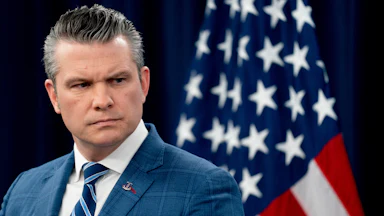 Defense Secretary Pete Hegseth frowns and looks to the side during a press conference