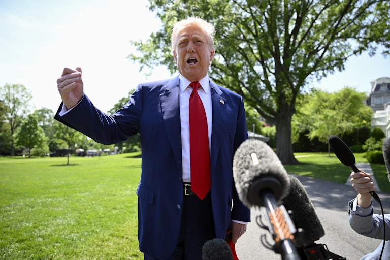 Donald Trump gestures while speaking to reporters outside the White House