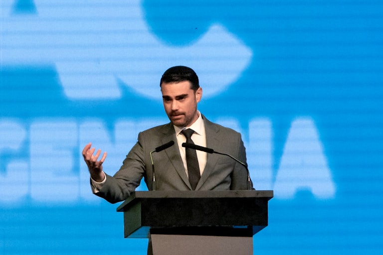 Ben Shapiro gestures while speaking at a podium