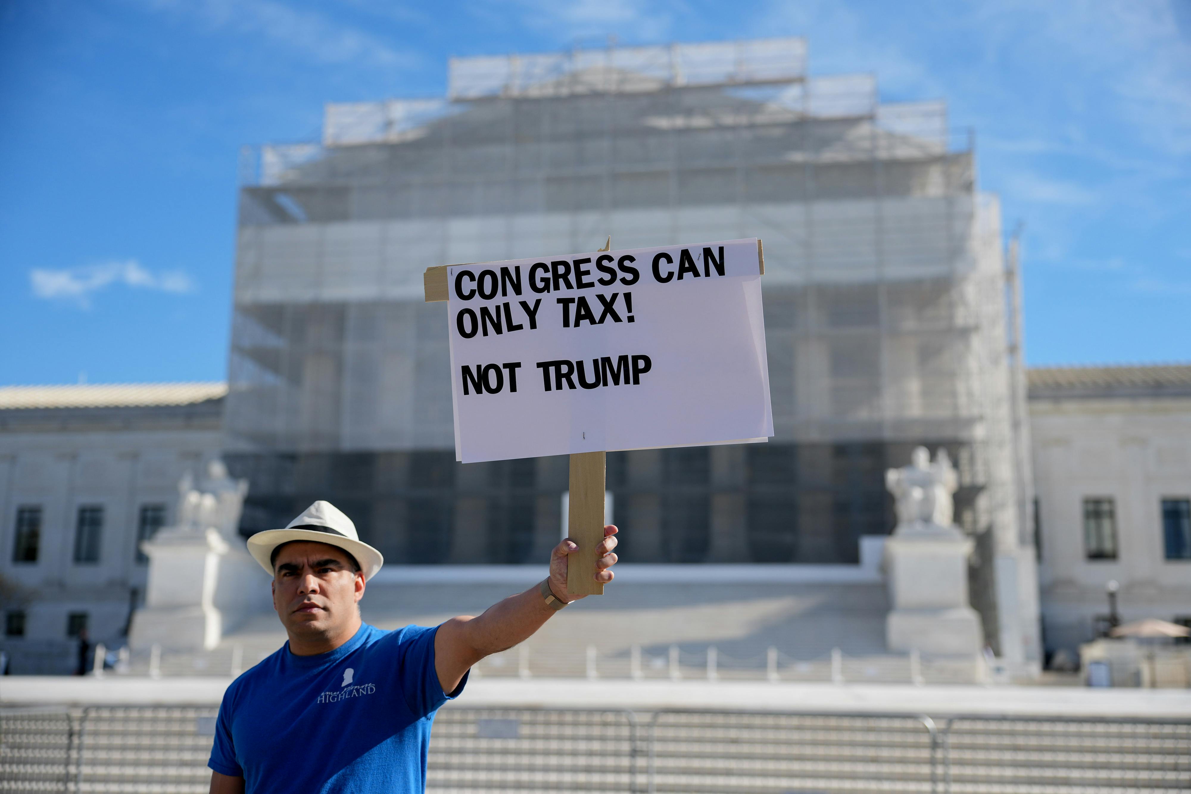 A person holds a sign that says, "Congress can only tax! Not Trump" outside the Supreme Court