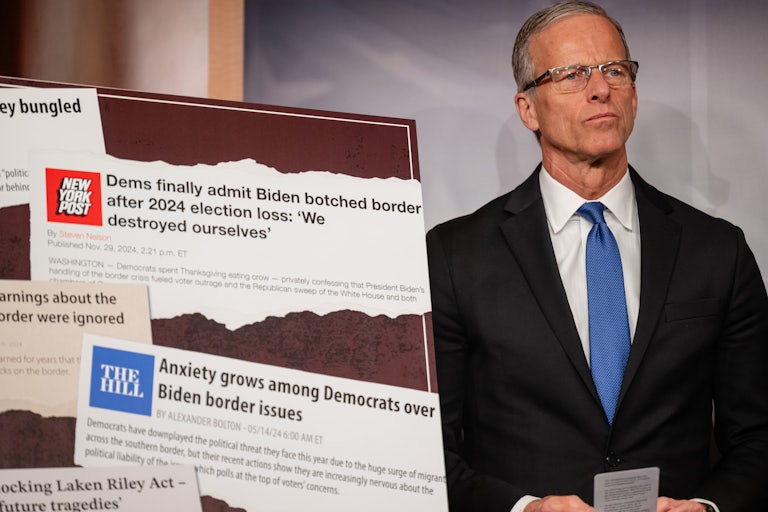 Senate Majority Leader John Thune stands by a poster during a press conference on the Laken Riley Act
