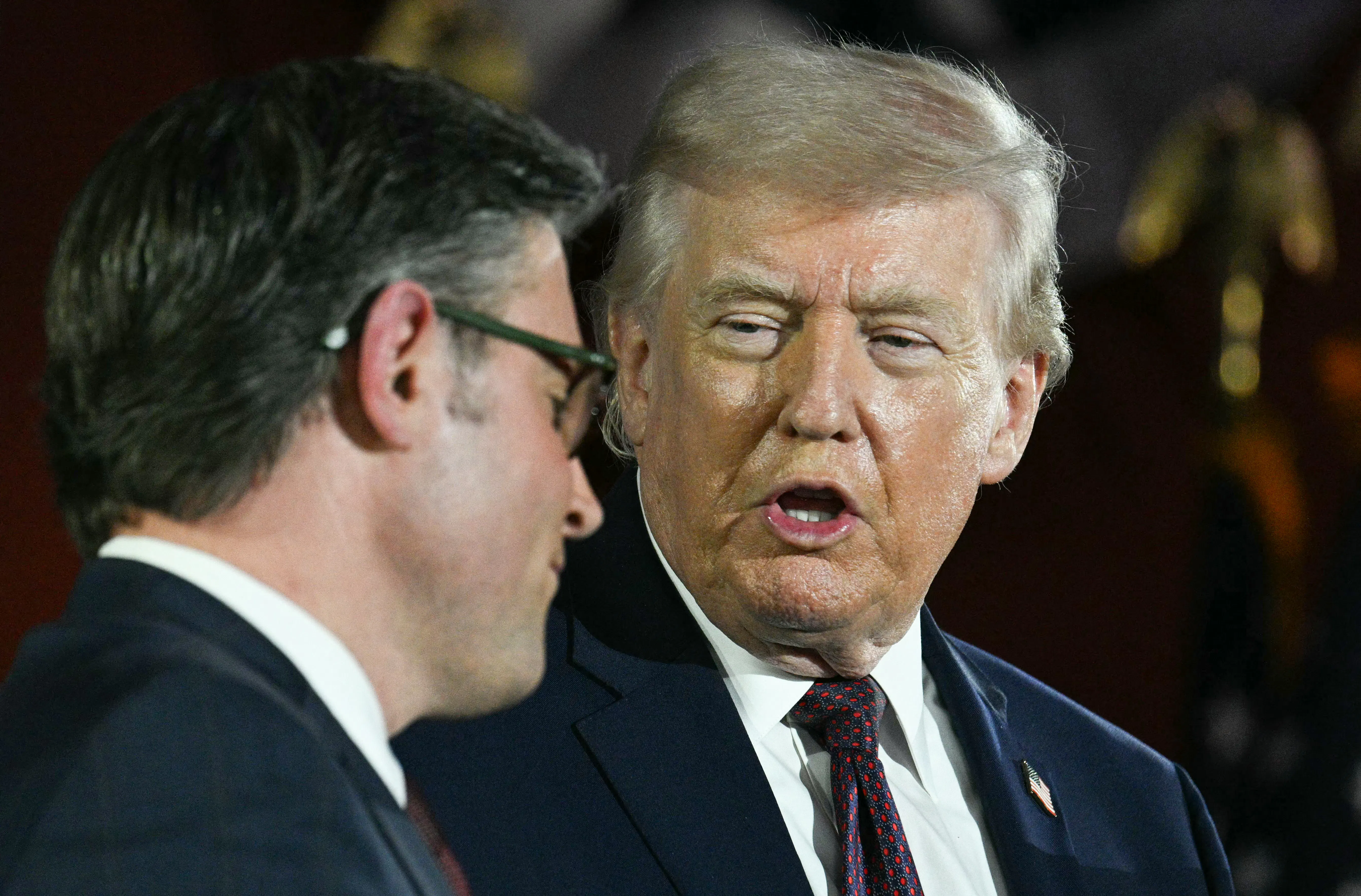 President Donald Trump speaks as House Speaker Mike Johnson listens