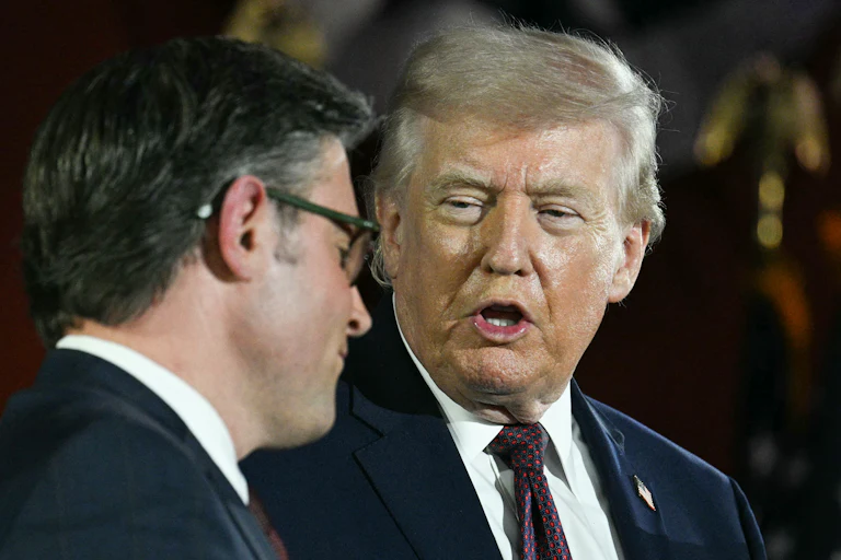 President Donald Trump speaks as House Speaker Mike Johnson listens