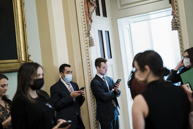 Senate staffers wait outside a room where Senate Democrats hold their weekly policy luncheon on Capitol Hill.