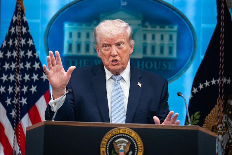 Donald Trump gestures while speaking at a podium