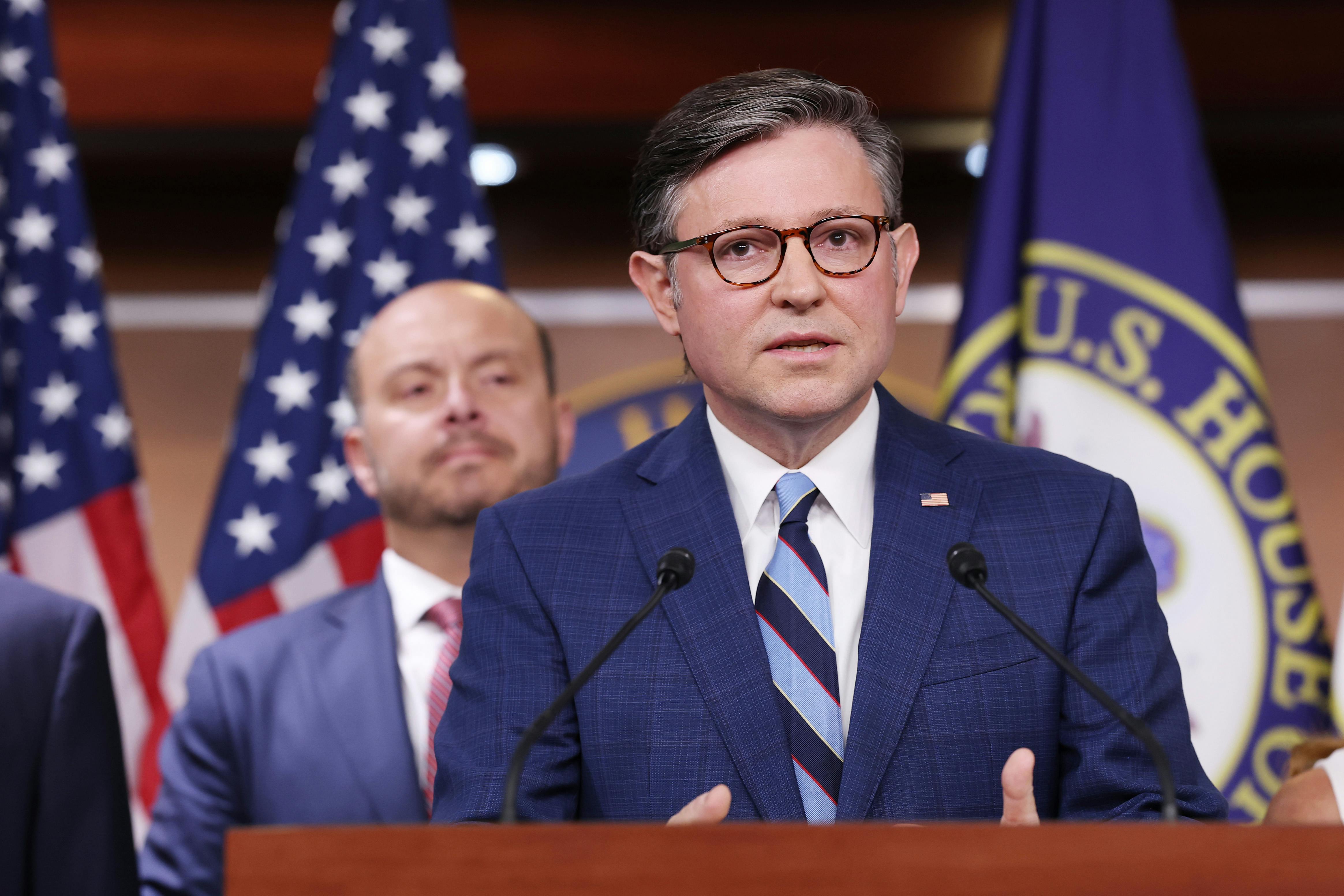 House Speaker Mike Johnson speaks at a podium during a press conference
