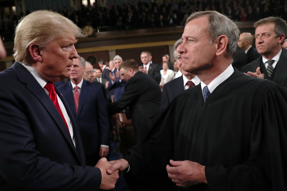 President Donald Trump shakes hands with Chief Justice John Roberts.