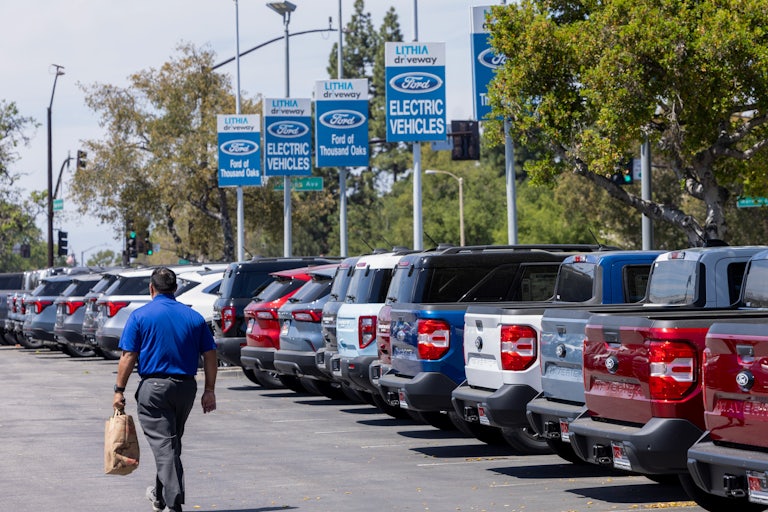 An employee walks in a Ford car lot.
