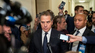 Hunter Biden surrounded by reporters holding out mics and phones for recording purposes