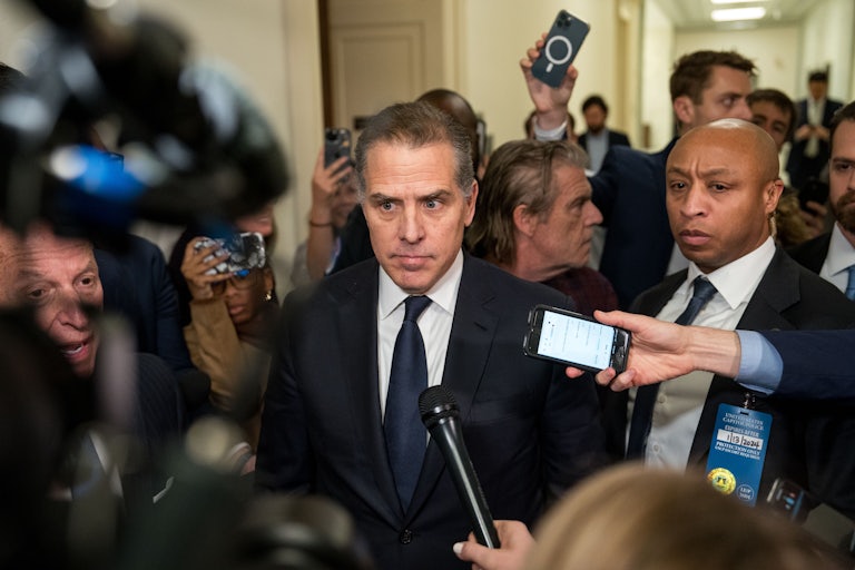 Hunter Biden surrounded by reporters holding out mics and phones for recording purposes