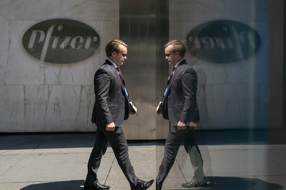 A mirror creates the illusion that a man in a suit is walking into and out of Pfizer's headquarters.