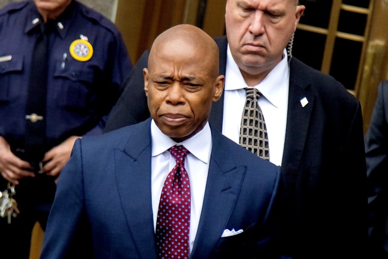 Eric Adams looks down while walking out of a New York City courthouse