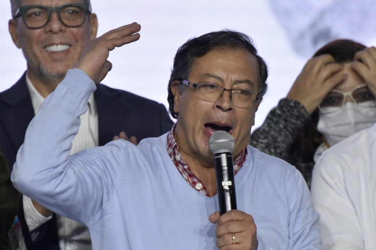 Gustavo Petro gestures while speaking, with others behind him.