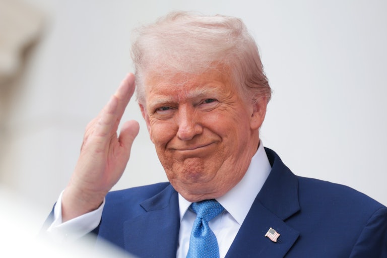 Donald Trump smiles and salutes during an event at Arlington National Cemetery