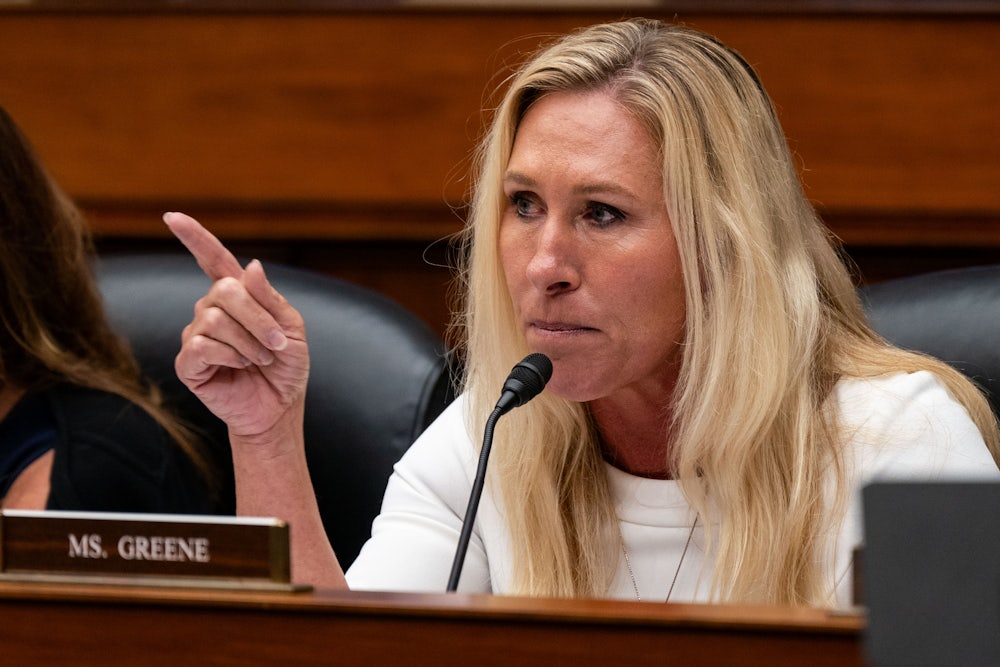 Representative Marjorie Taylor Greene points a finger during a congressional hearing.