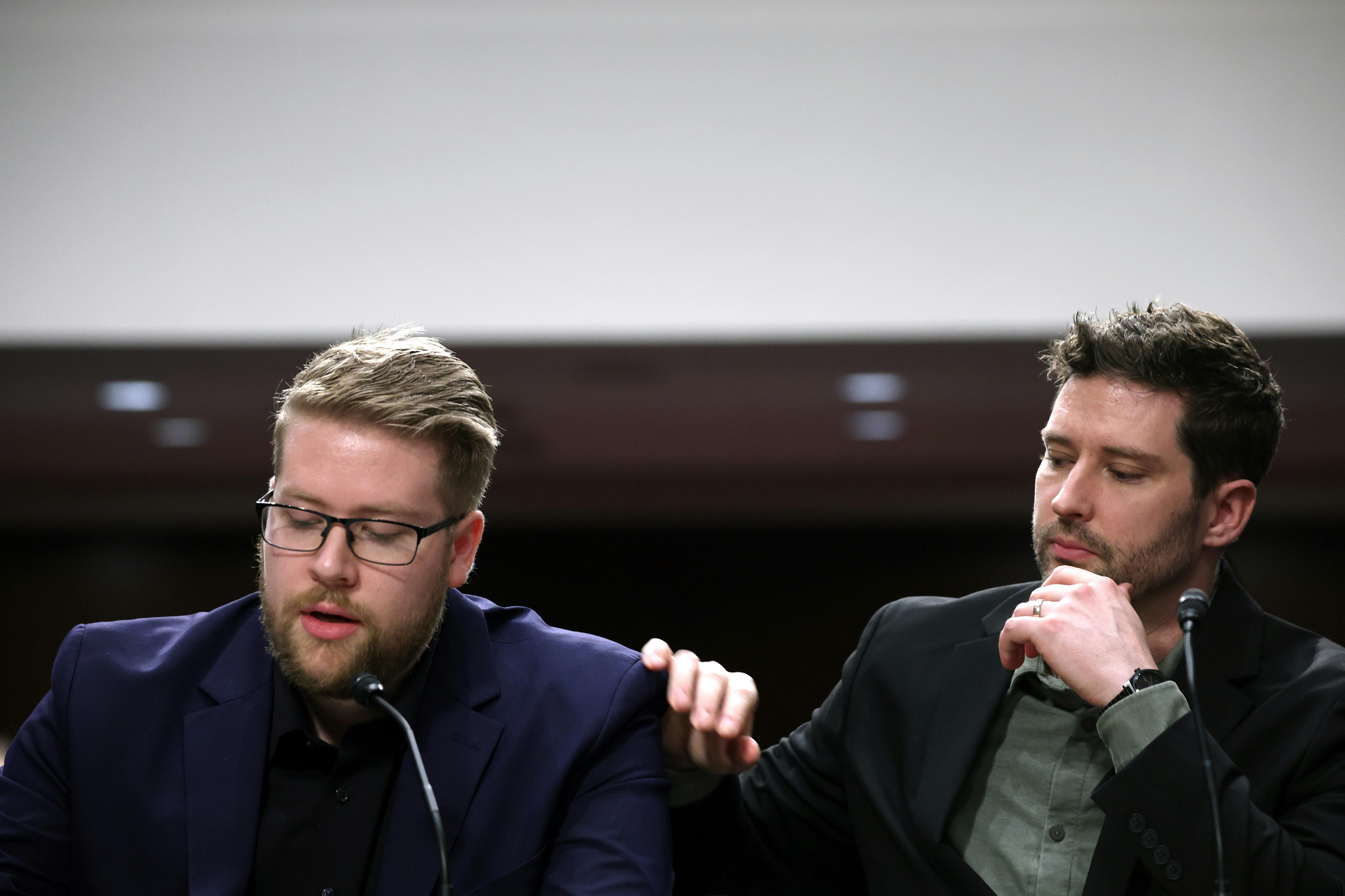 Brent Grancer places his hand on Luke Granger's shoulder as he speaks.