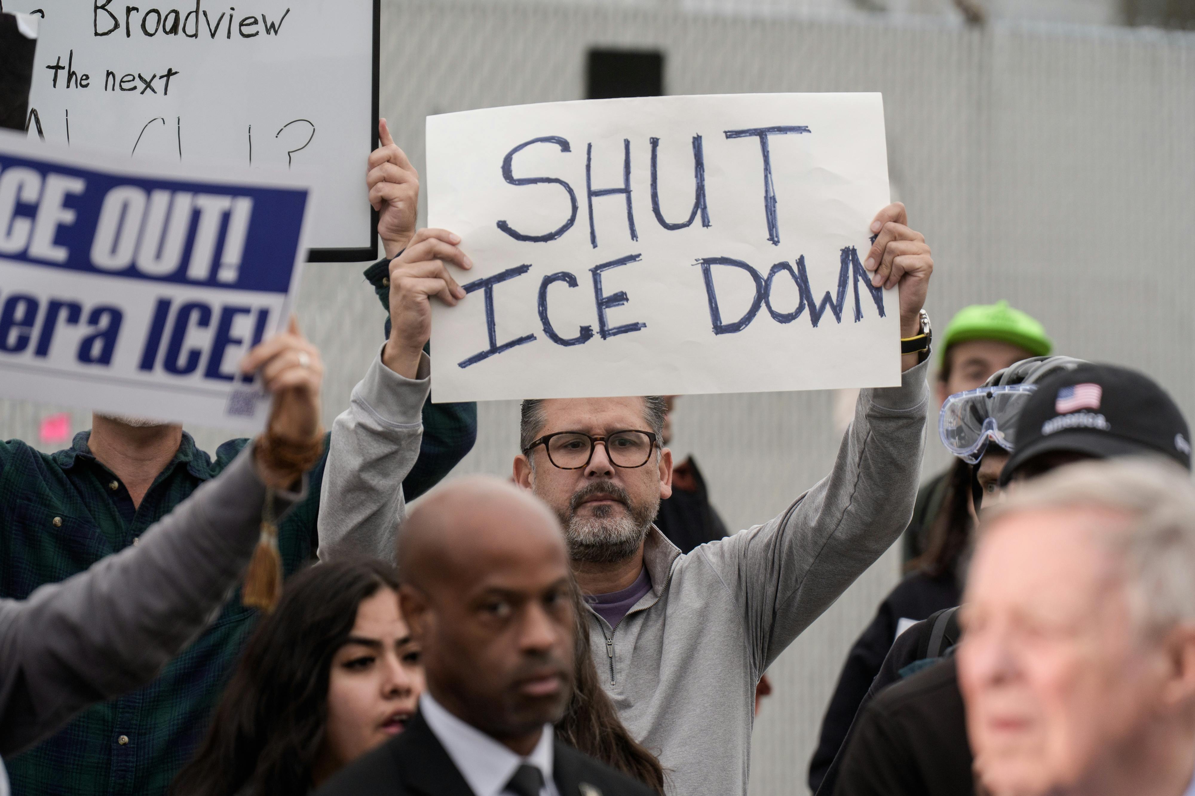 A person holds up a sign that says, "Shut ICE down" during a protest outside an ICE facility near Chicago