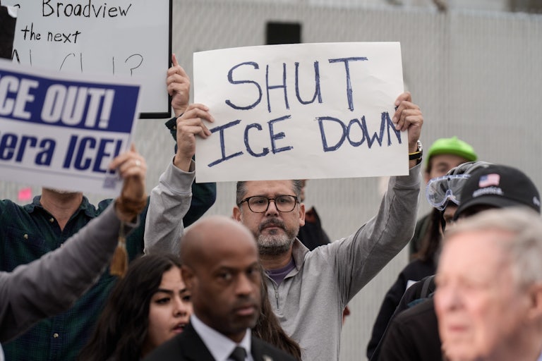 A person holds up a sign that says, "Shut ICE down" during a protest outside an ICE facility near Chicago