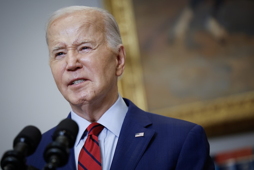 Joe Biden speaks behind a lectern in the White House's Roosevelt Room.