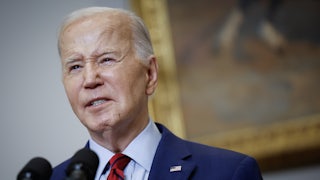 Joe Biden speaks behind a lectern in the White House's Roosevelt Room.