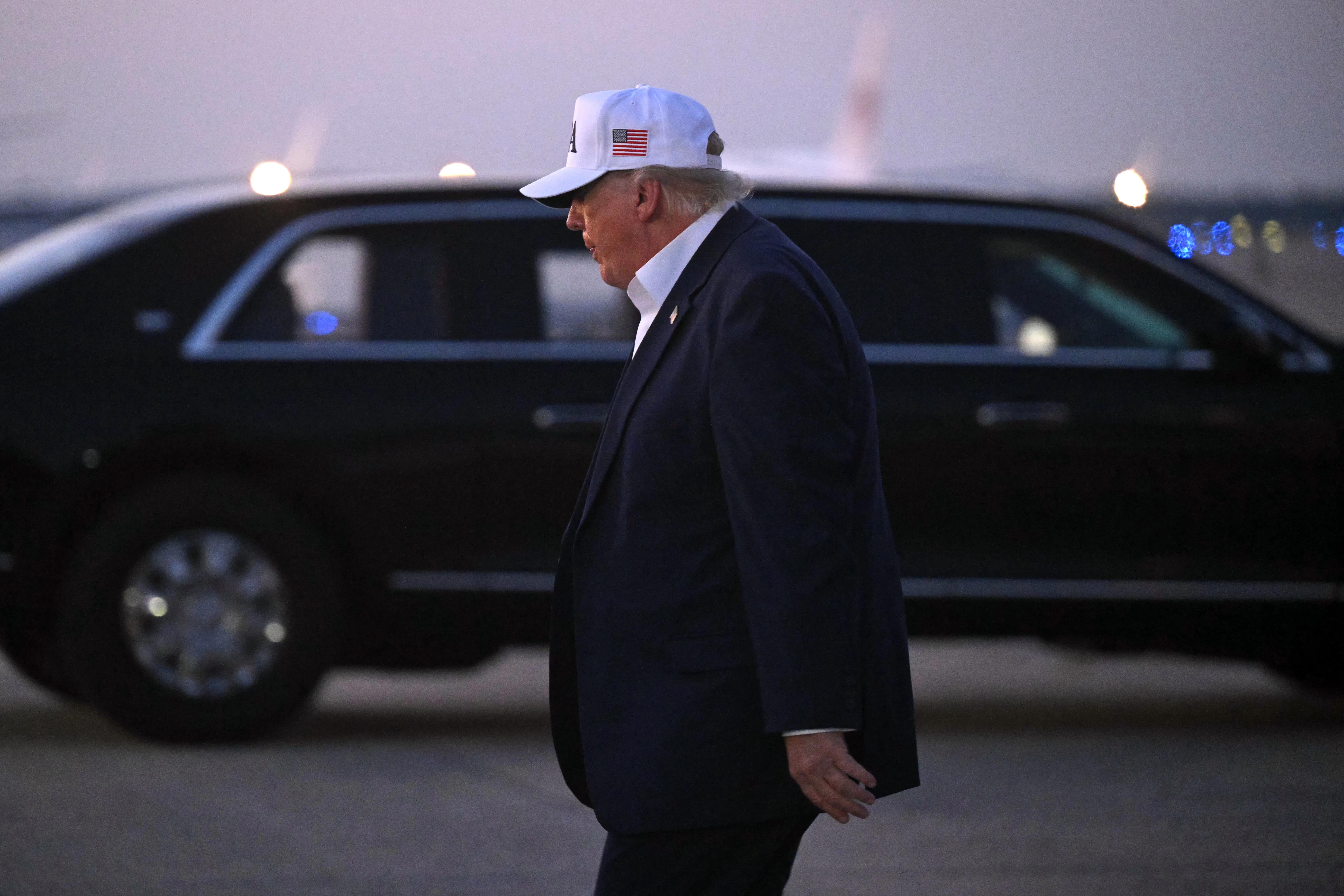 Donald Trump, seen in profile, walks away after disembarking from Air Force One