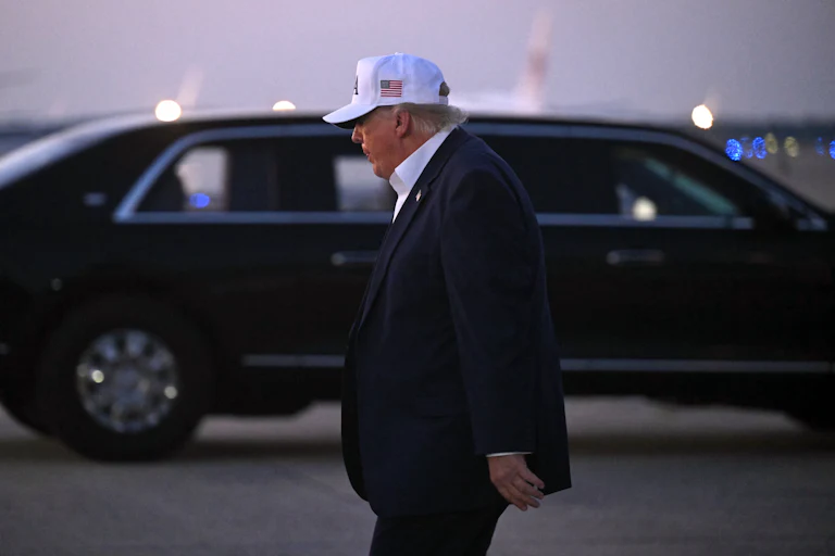 Donald Trump, seen in profile, walks away after disembarking from Air Force One
