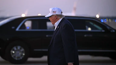 Donald Trump, seen in profile, walks away after disembarking from Air Force One