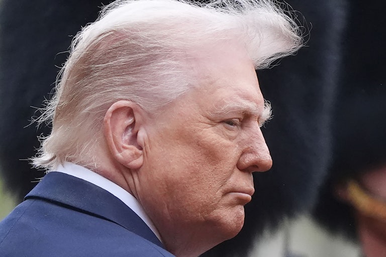 Donald Trump stands in profile while the wind blows his hair up