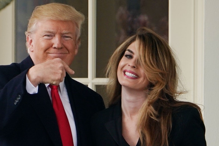 Donald Trump points and smiles at Hope Hicks, who is smiling and has bangs covering one of her eyes
