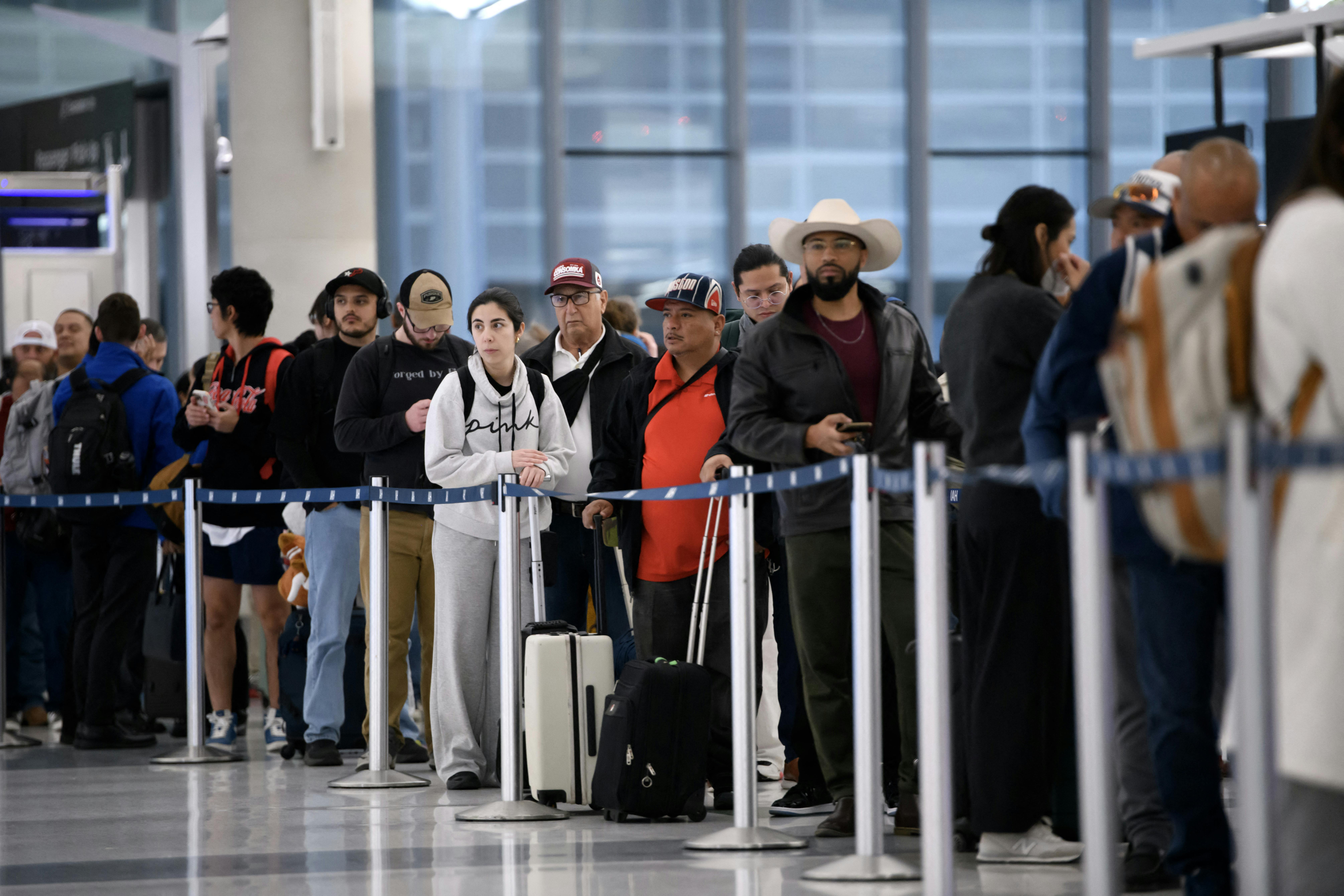 People wait in a long security checkpoint George Bush Intercontinental Airport in Houston, Texas.