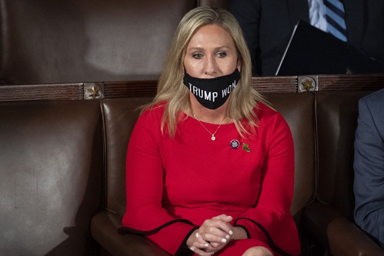 Marjorie Taylor Greene wears a mask that says "TRUMP WON." Her mask is below her nose and doesn't cover her whole mouth.