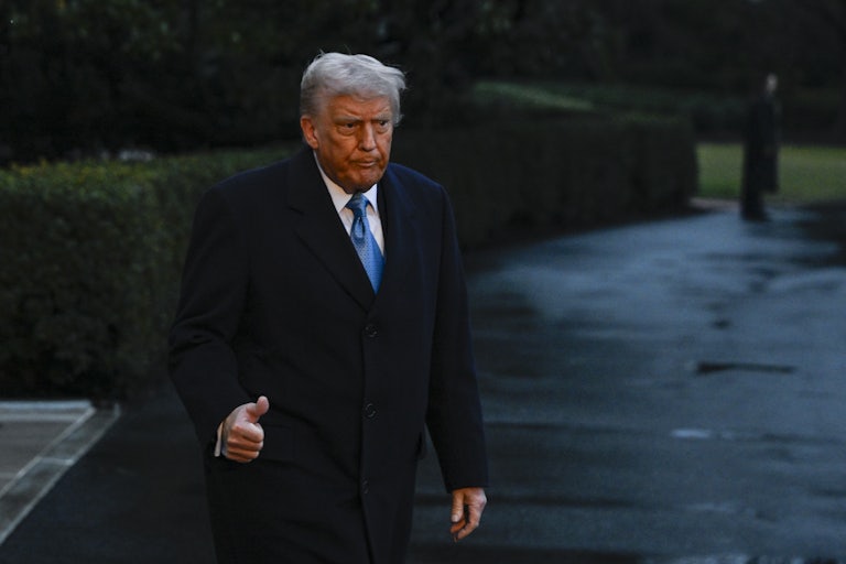 Donald Trump purses his lips and gives a thumbs-up while leaving the White House